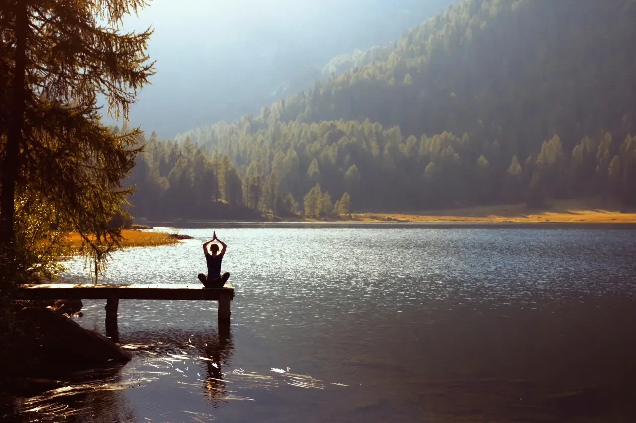 Person meditating on dock