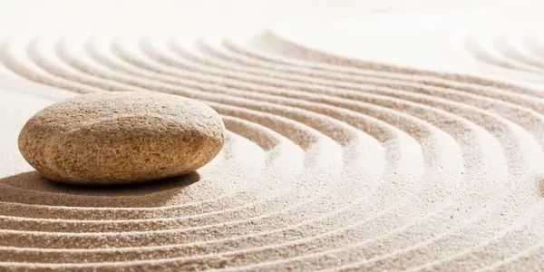 Zen garden with smooth stone and raked sand — symbol of inner peace and foundation