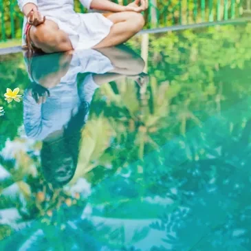 Person meditating peacefully by a reflective pool